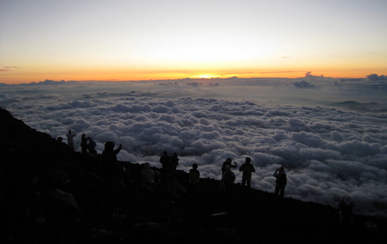 富士山で雲海からの日の出を見ようと待機している登山者